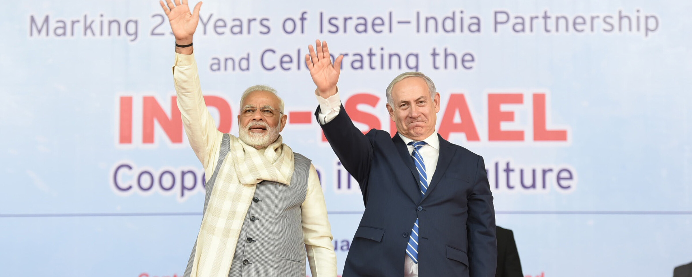 Indian Prime Minister Narendra Modi and Israeli Prime Minister Benjamin Netanyahu wave to an unseen audience