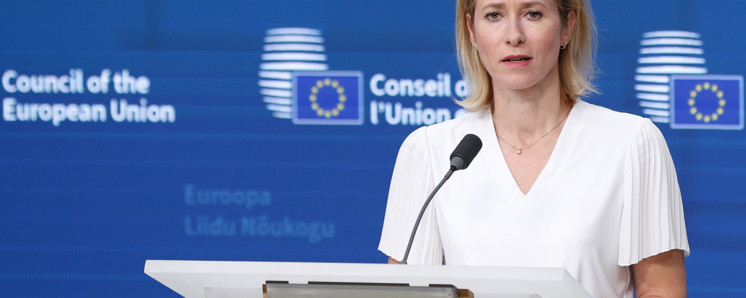 The European Union's foreign policy chief Kaja Kallas stands at a lectern with a microphone