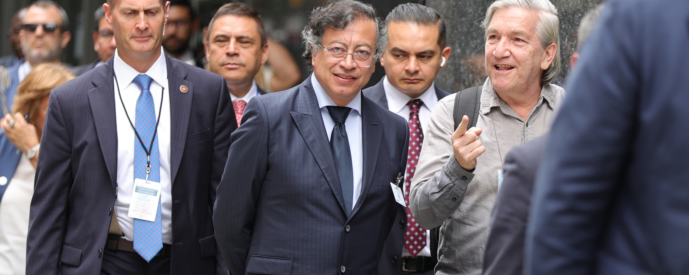 A man in a suit flanked by others in suits