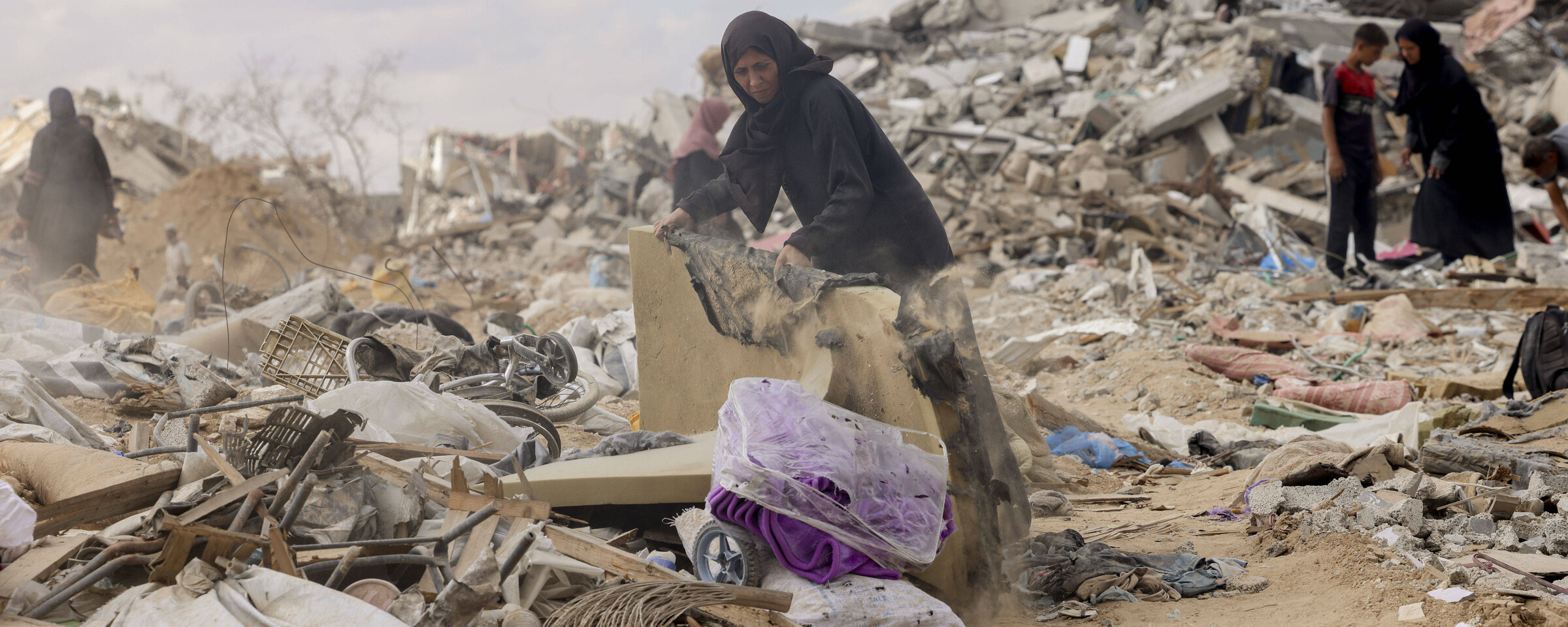 A woman sifts through rubble