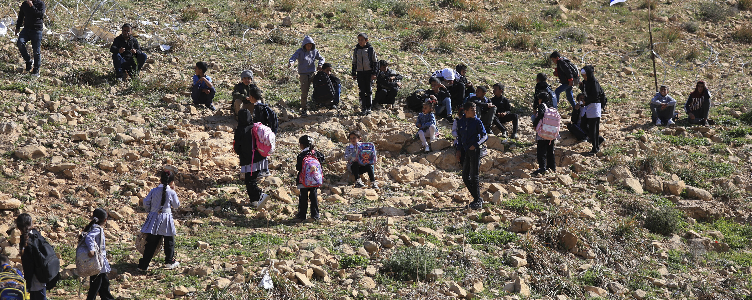 Children in a field near an Israeli flag