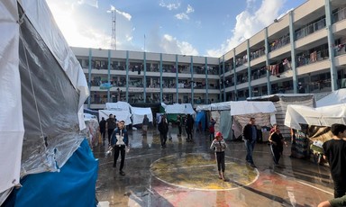 Makeshift tents in the courtyard of an UNRWA school in Rafah, the ground wet from a recent rain