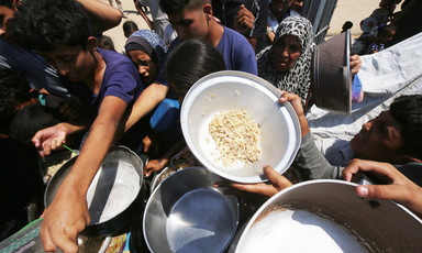 people crowd around a charity food distribution center for rice