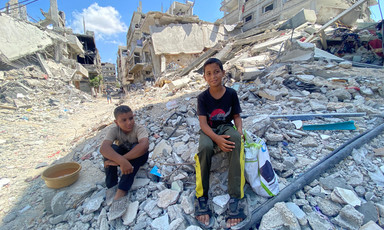 two boys sit on rubble