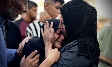 The head of crying young woman is held in the hands of another woman