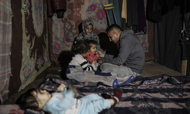 a family huddles together in their tent 