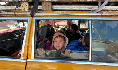 A boy looks out the window of fully loaded taxi