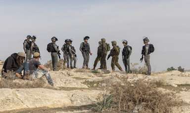 A number of Israeli soldiers and settlers on a hilltop in the occupied West Bank 