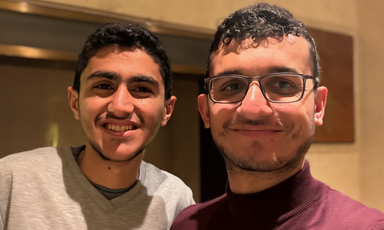 Two young men smile in a close-up portrait