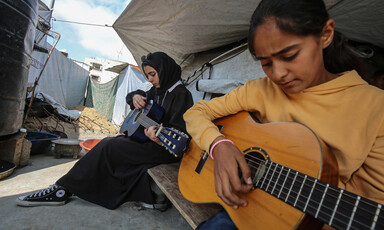 Two girls play guitar