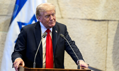 Trump speaks in front of an Israeli flag