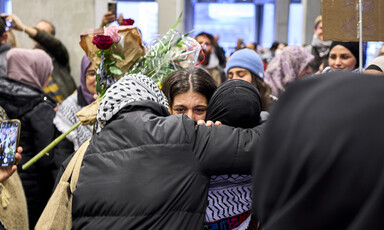 Two women hug in a crowd