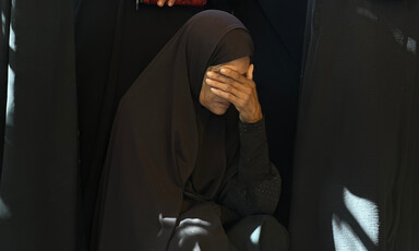 A woman clad in black mourns