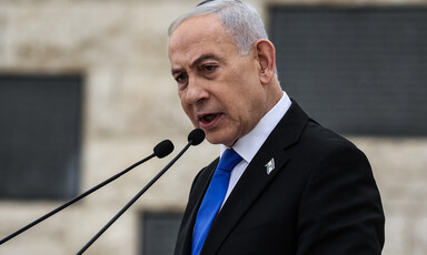 Netanyahu speaks into a microphone