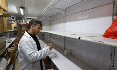 A man searches empty shelves