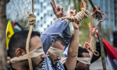 Three men seen from neck up are blindfolded with their hands tied with rope or a noose around their head
