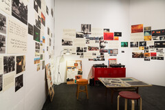 Brightly-lit room with collage of photographs on walls