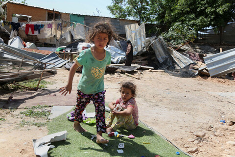 Two girls playing past the debris of homes after Israeli forces demolished them in Khan al-Ahmar. 