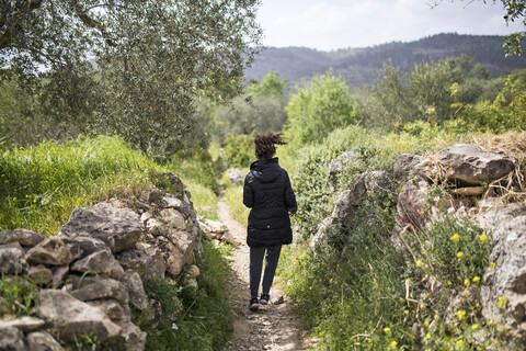 Girl seen from behind walking on path