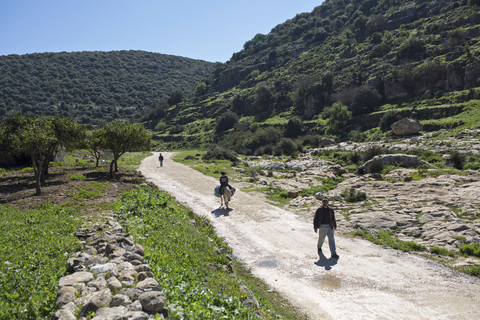 A man and child on a road between mountains