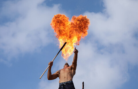 Heart-shaped cloud of fire hangs over a shirtless man