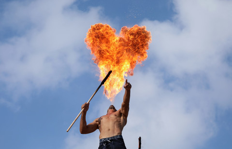 Heart-shaped cloud of fire hangs over a shirtless man 