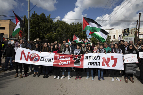 Demonstrators holding large banner, flags 