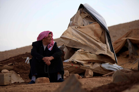 Man looks at the pile of rubble around him