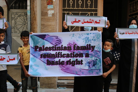 Two children hold a poster reading "Palestinian family reunification is a basic right"