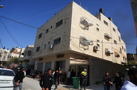 A three-story building with people milling about outside