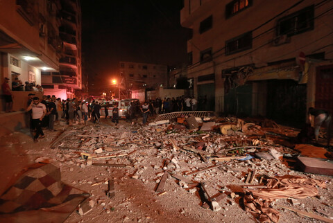 People stand around an area that has been severely damaged 