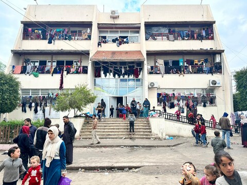 Clothes can be seen hanging from the balconies of and many people can be seen near the entrance of the Palestine Technical College in central Gaza  