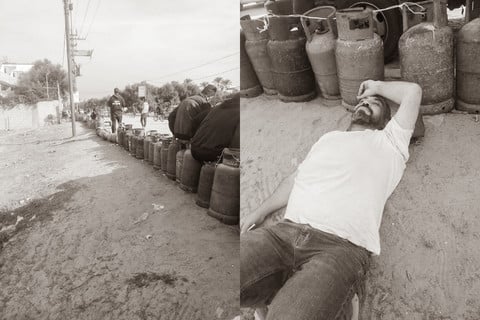 A row of gas canisters stretches into the distance, and a man lying on the ground next to the canisters