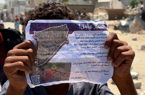 A person holds up an evacuation notice from Israel