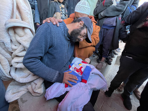 A man prepares his infant for burial