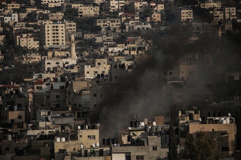 Smoke rises amid a dense residential area 