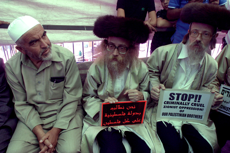 Raed Salah sits next to two anti-Zionist Orthodox Jews
