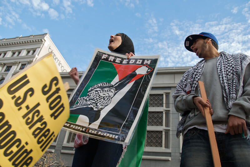 Young man and woman carry signs bearing solidarity messages