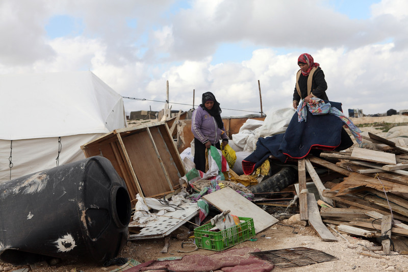 Women sort through rubble of destroyed homes