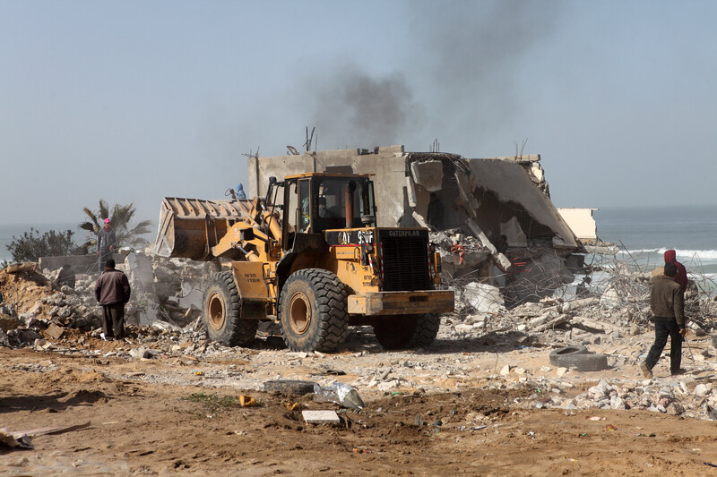 Earth-moving machine bulldozes homes along coast