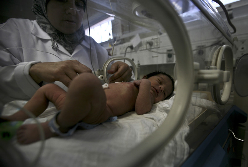 Nurse tends to baby in incubator