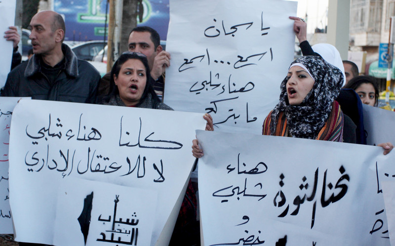 Demonstrators hold Arabic-language signs in support of Hana al-Shalabi