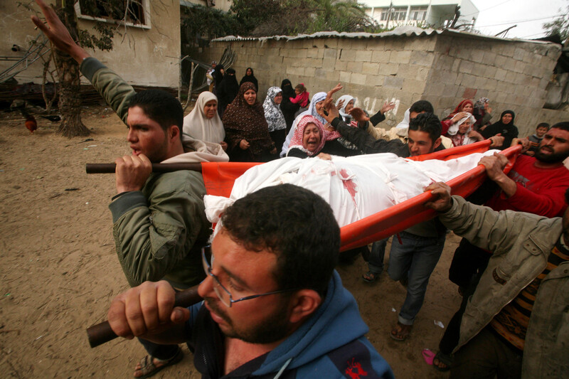 Women mourners stand to side as men carry body of killed Gaza man