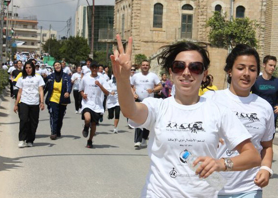 Woman gives &quot;peace&quot; hand gesture during 5k run