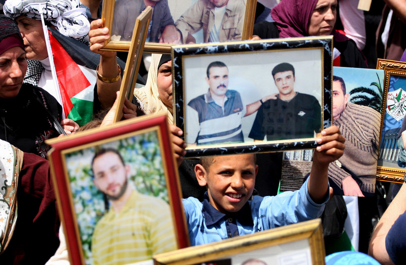Demonstrators display portraits of loved ones in Israeli prisons