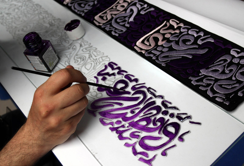 Man works on calligraphic art