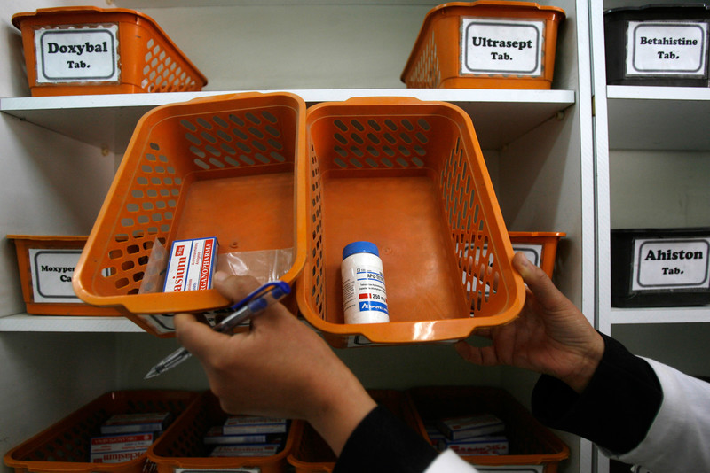 Pharmacist displays empty stocks of medicine