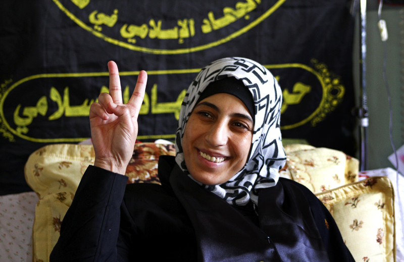 Hana al-Shalabi makes &quot;victory&quot; hand gesture while resting on bed