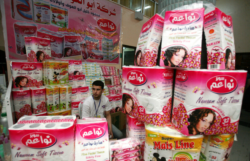 Man sits surrounded by colorfully packaged paper products