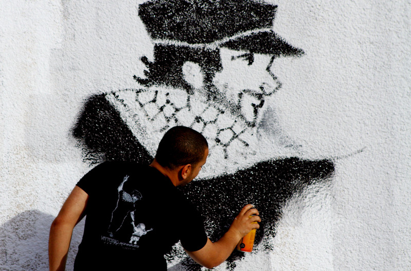 Man spray-paints portrait of Vittorio Arrigoni